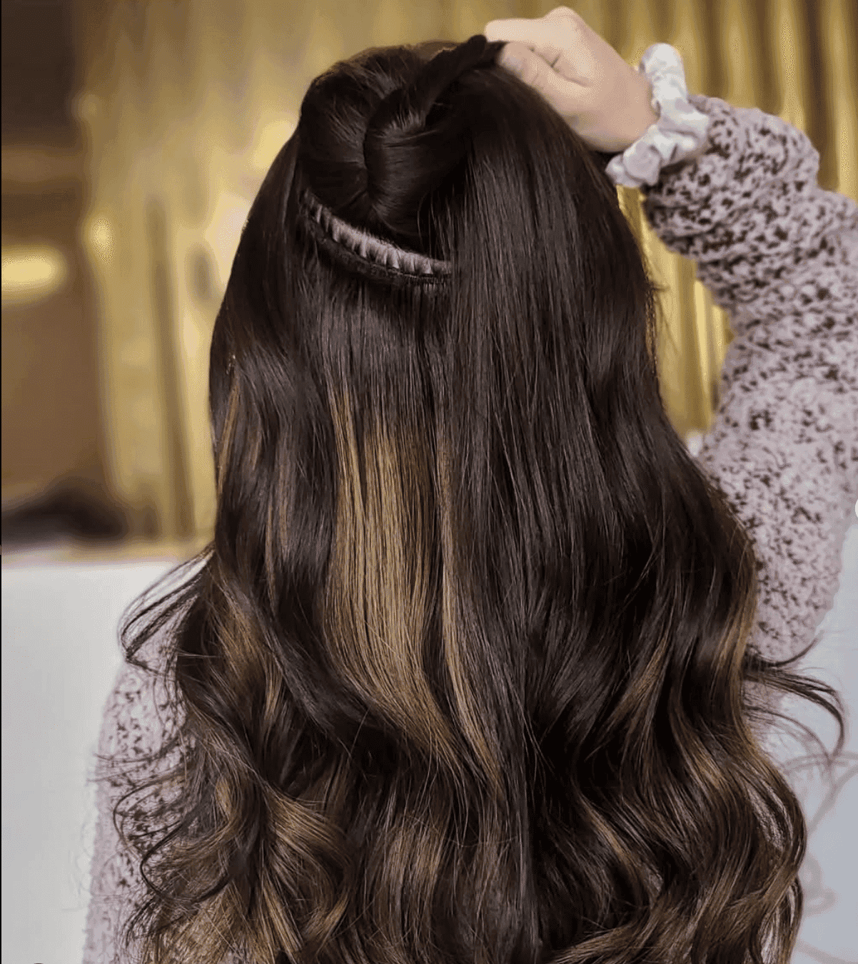 Elegant half-up hairstyle with spiral waves and a highlight streak.