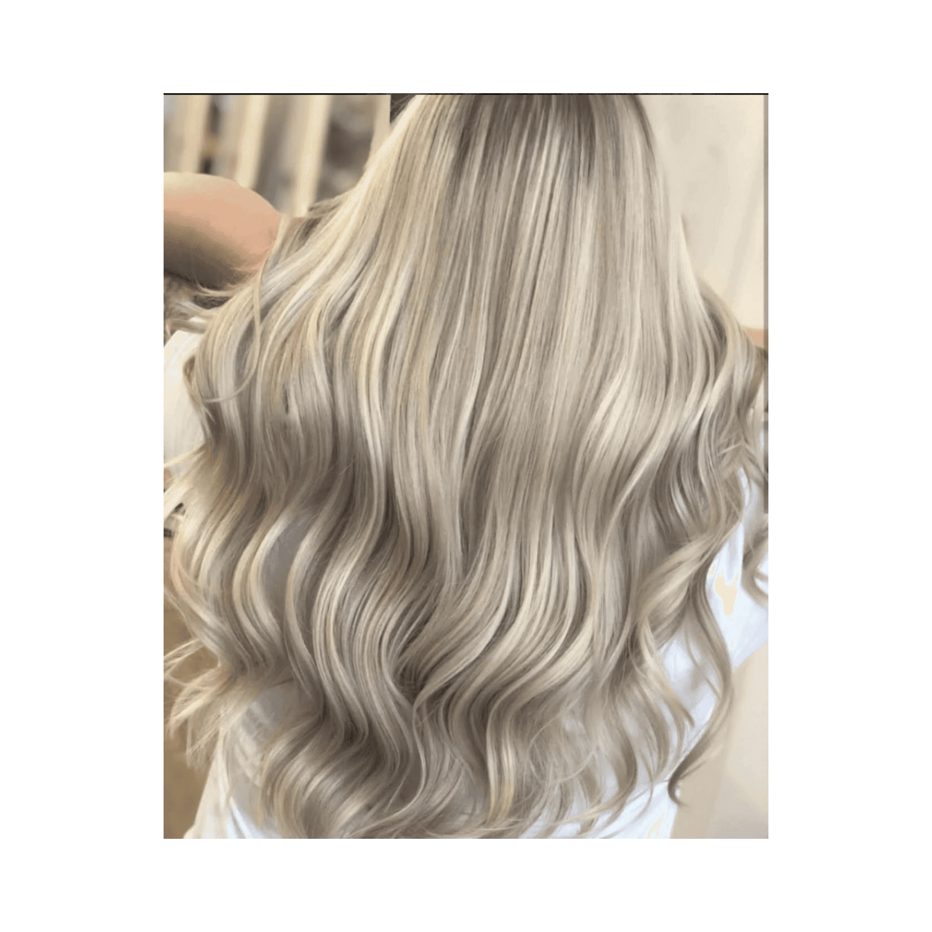 Long, wavy platinum blonde hair cascading over a white shirt.